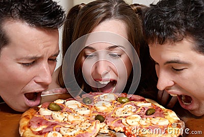 Happy company of youth eating a pizza