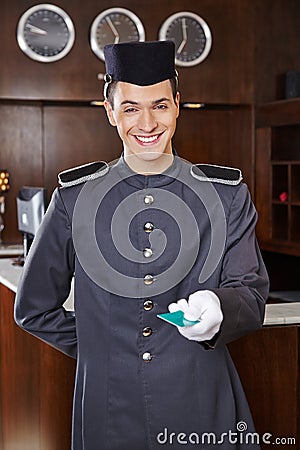 Happy concierge giving hotel key card