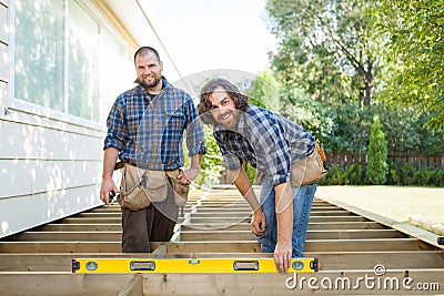 Happy Construction Workers With Spirit Level At