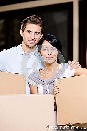 Happy couple carrying pasteboard boxes