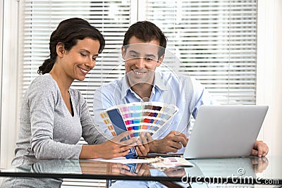 Happy couple choosing colors to paint new house