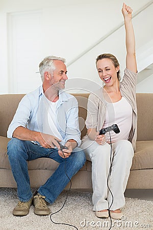 Happy couple having fun on the couch playing video games