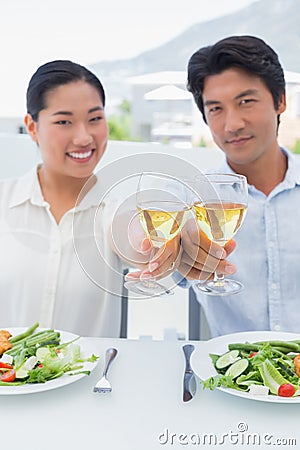 Happy couple having white wine with a meal