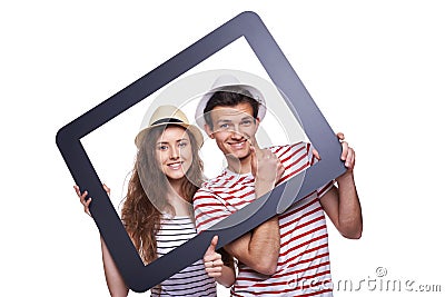 Happy couple looking through tablet frame