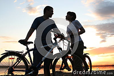 Happy couple riding bicycles outside, healthy life