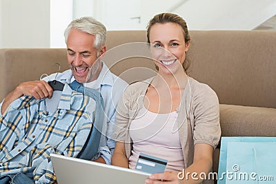 Happy couple shopping online on the couch