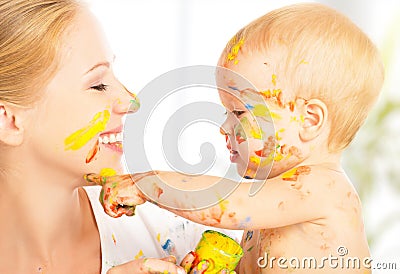 Happy dirty baby draws paints on her face of mother