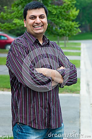 Happy East Indian Man standing outside his house