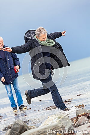 Happy elderly senior couple walking on beach