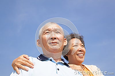 Happy elderly seniors couple with cloud background