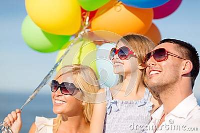 Happy family with colorful balloons outdoors