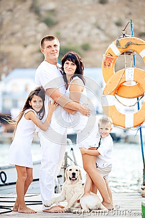 Happy family with dog on berth in summer