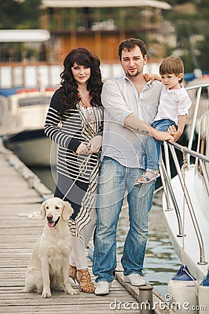 Happy family with dogs on the Quay in the summer