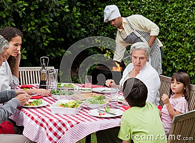 Happy family eating in the garden