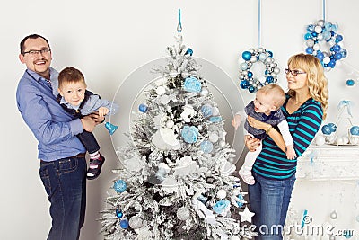 Happy family of four persons decorating christmas tree