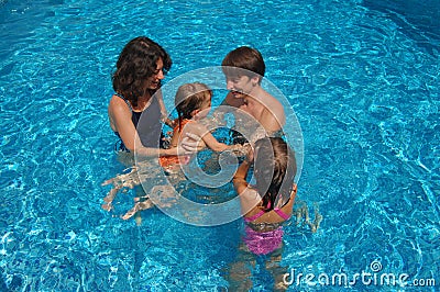 Happy family of four in the pool