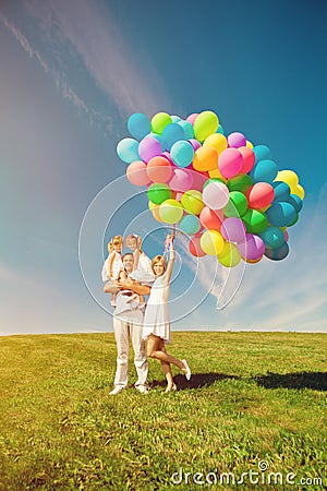 Happy family holding colorful balloons. Mom, ded and two daughte