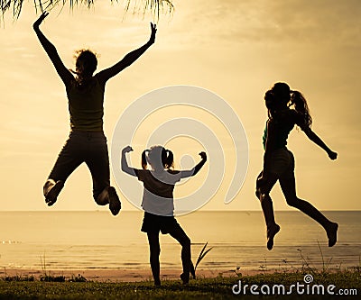 Happy family jumping on the beach