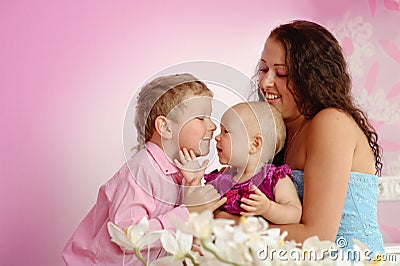 Happy family mother and her children boy and girl sitting indoor