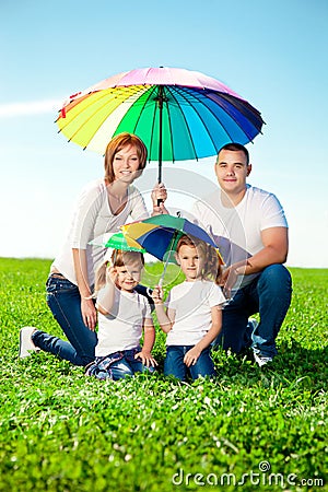 Happy family in outdoor park at sunny day. Mom, dad and two dau