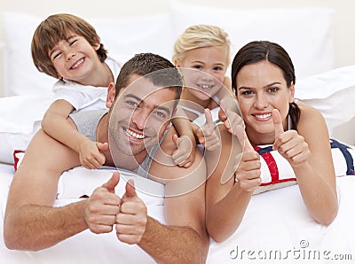 Happy family playing in parent s bed