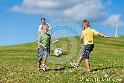 Happy family is playing soccer in summer