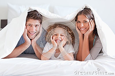 Happy family posing under a duvet