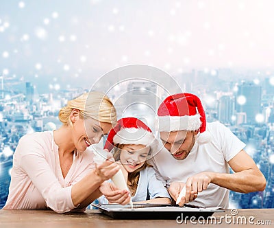 Happy family in santa helper hats cooking