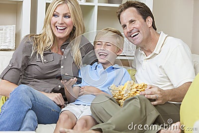 Happy Family Sitting on Sofa Watching Television