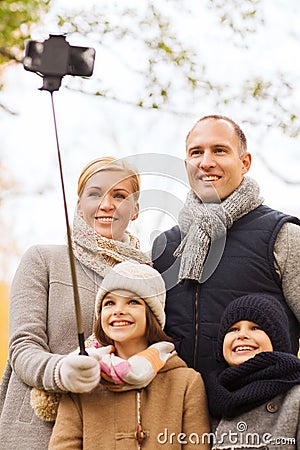 Happy family with smartphone and monopod in park