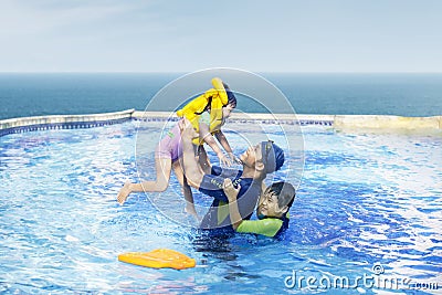 Happy family swimming on the pool