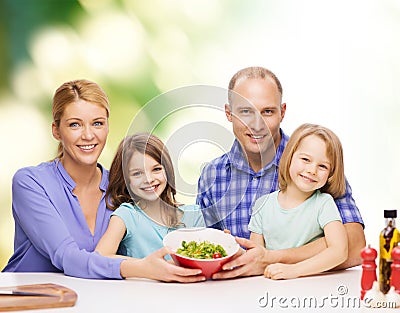 Happy family with two kids with salad at home