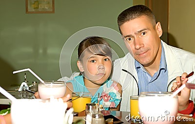 Happy father and daughter celebrate in the cafe.