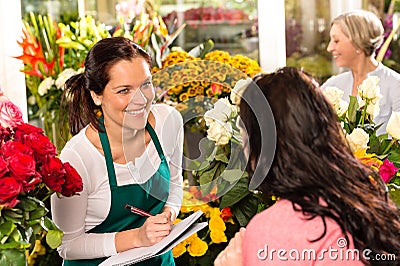 Happy florist writing flower shop talking customer