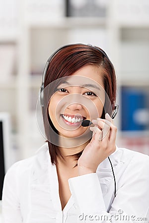 Happy friendly young Asian call centre operator