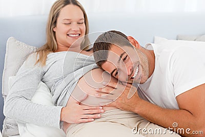 Happy future dad listening the belly of his wife