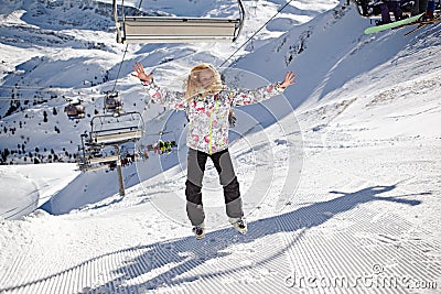 Happy girl jumping on mountains ski slope