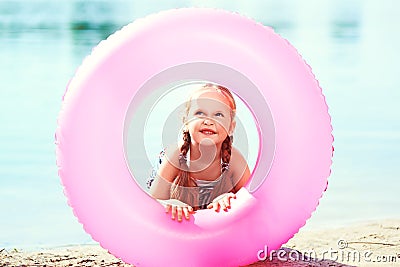 Happy girl and swim ring at the beach. toned image