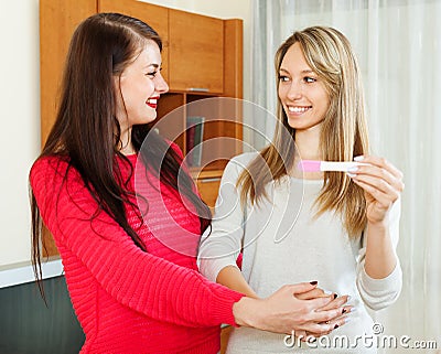 Happy girls with pregnancy test