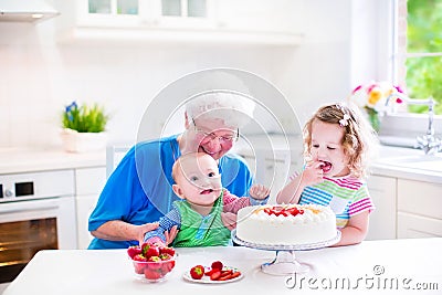 Happy grandmother baking cake with kids