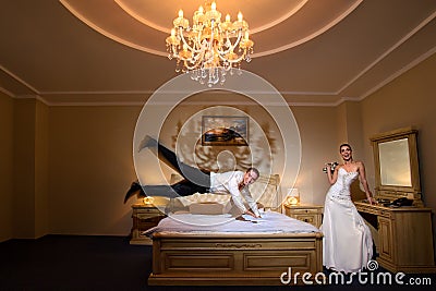 Happy groom flying on bed