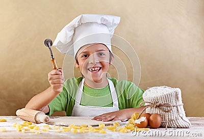 Happy kid with chef hat making pasta or cookie