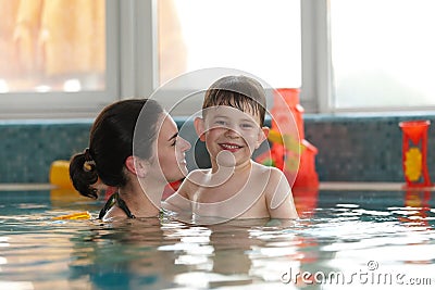 Happy kid and mother in swimming pool