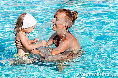 Happy kid playing with mother in swimming pool