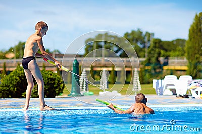 Happy kids having fun, playing in water park