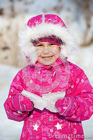 Happy laughing child in winter clothes with piece of ice