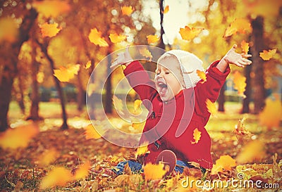 Happy little child, baby girl laughing and playing in autumn