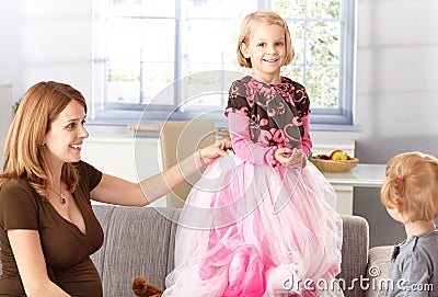 Happy little girl in princess skirt at home