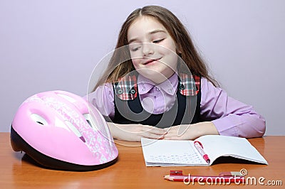 Happy little school girl doing homeworks at desk