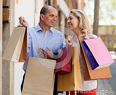 Happy lovers family holding bags after shopping